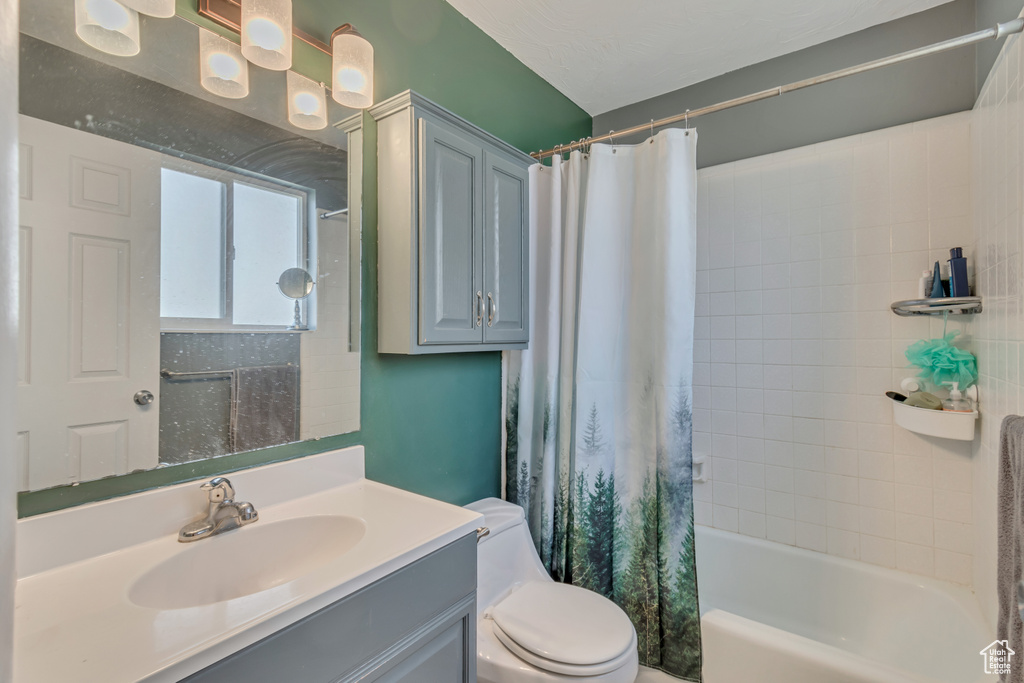 Full bath featuring shower / tub combo, vanity, and toilet