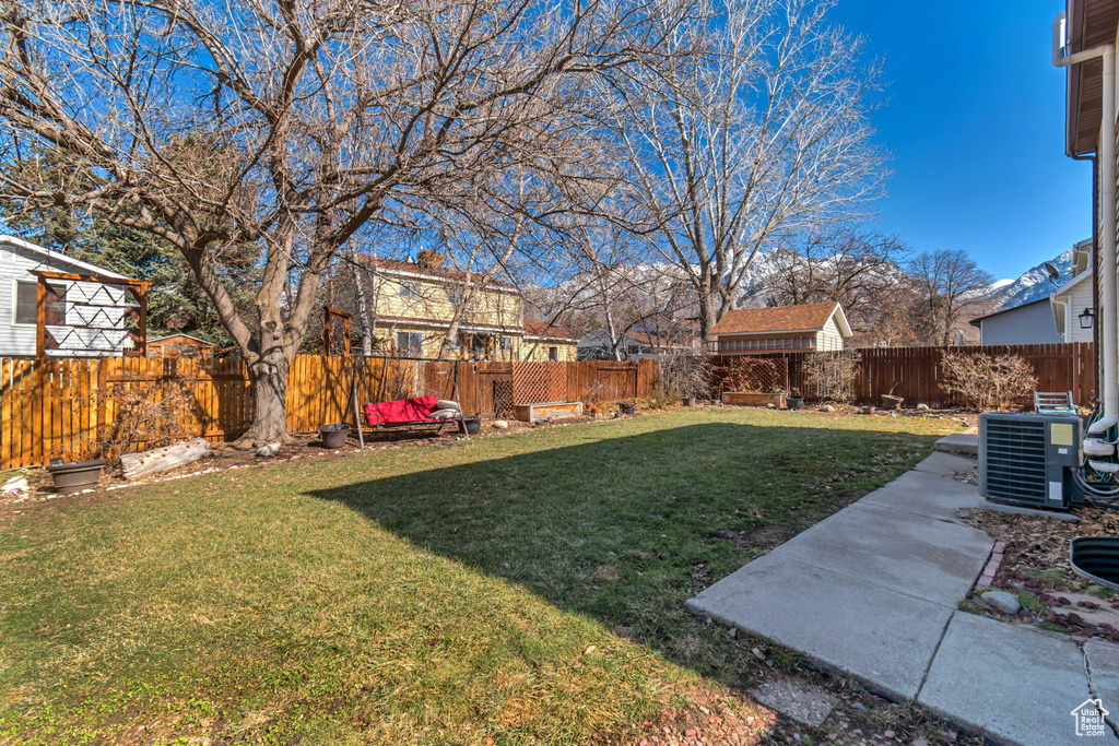 View of yard featuring central AC and a fenced backyard