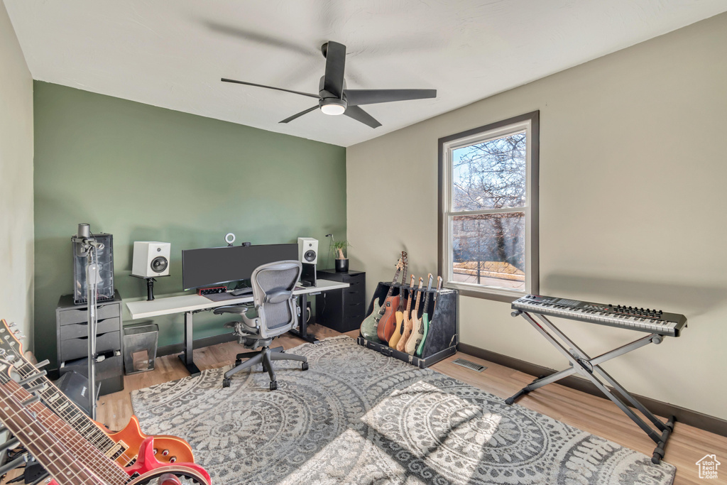 Office with wood finished floors, visible vents, and baseboards