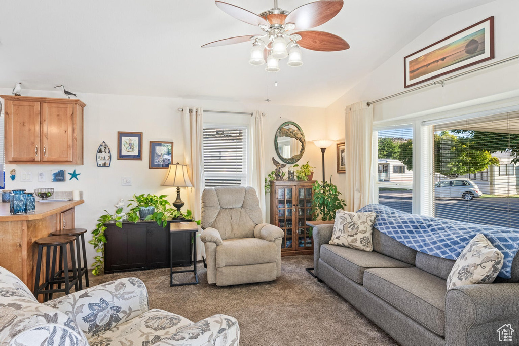 Carpeted living area featuring lofted ceiling and a ceiling fan