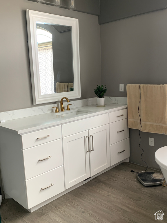 Bathroom featuring toilet, wood finished floors, and vanity