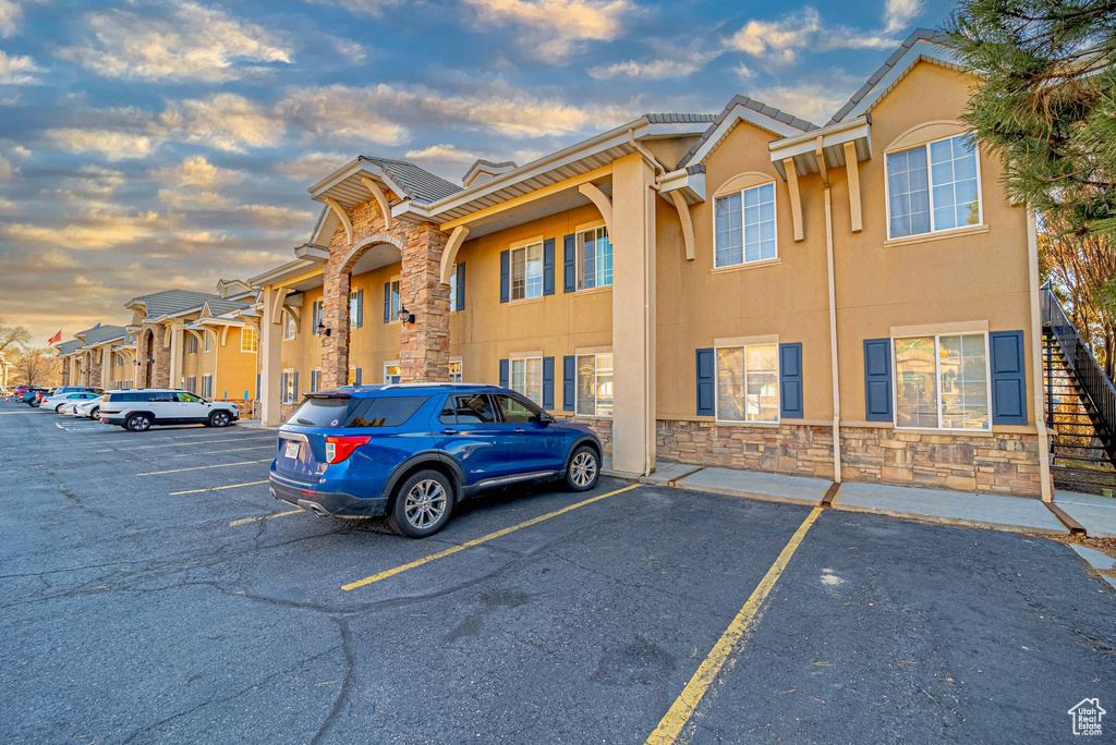 Property at dusk with uncovered parking and a residential view