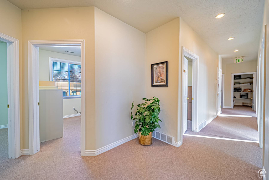Corridor with carpet, visible vents, baseboards, and recessed lighting