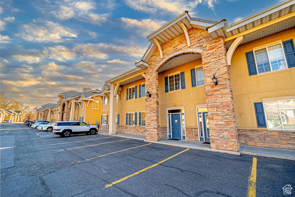 Property at dusk featuring uncovered parking and a residential view