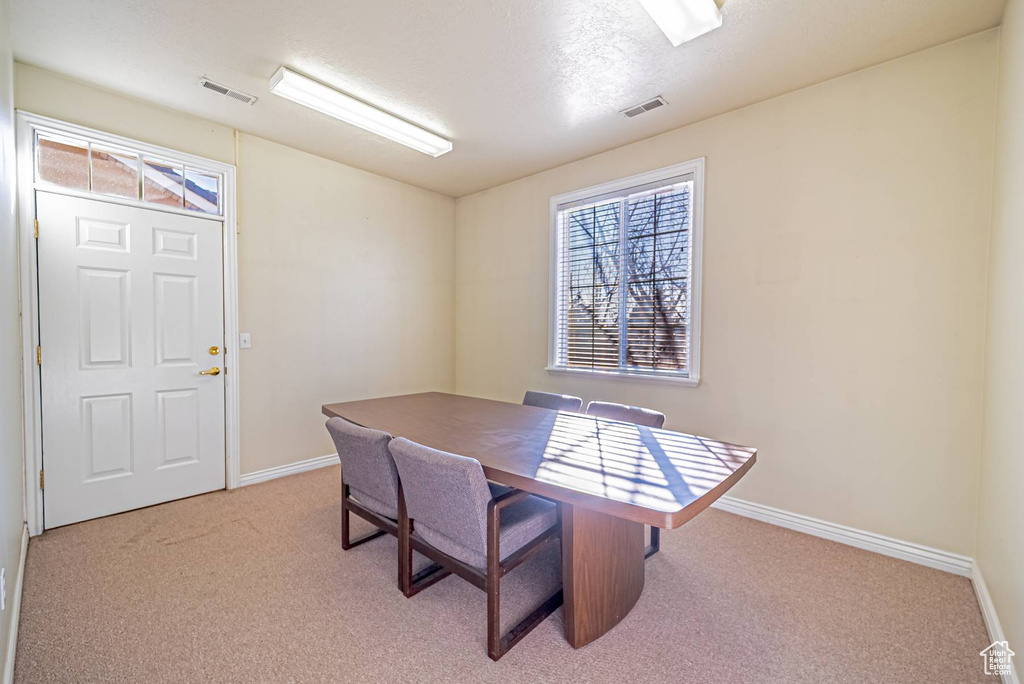Dining room with carpet floors, visible vents, and baseboards