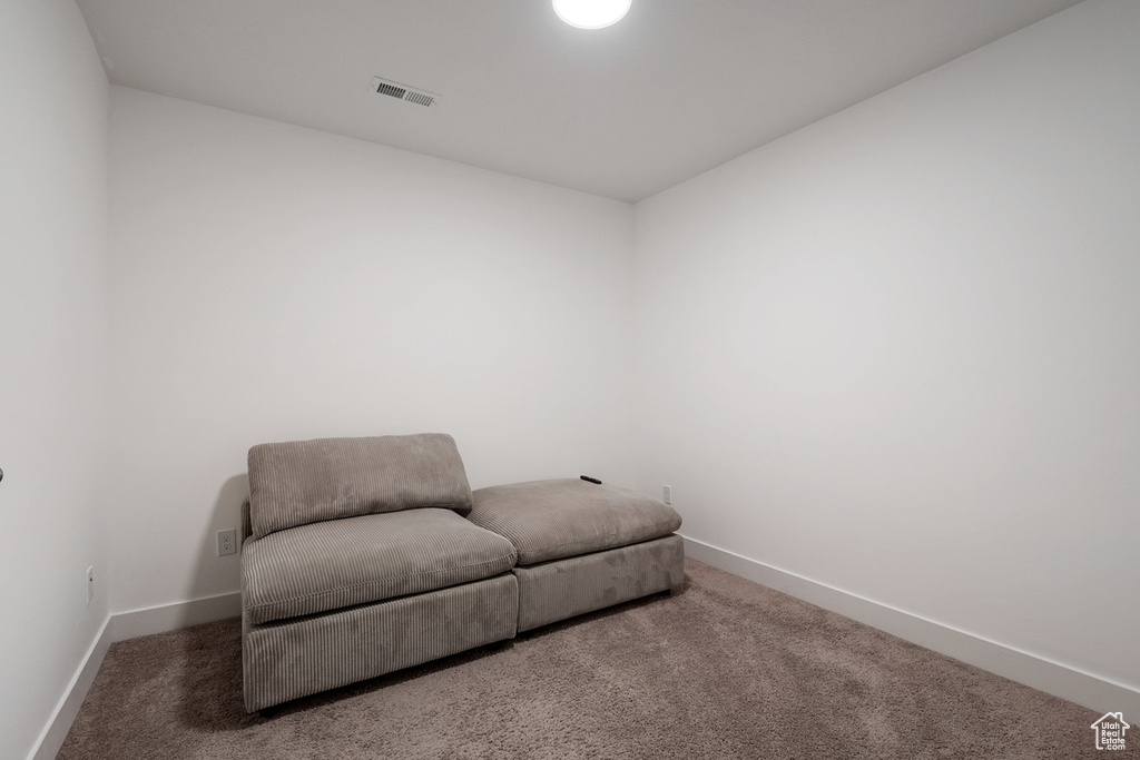 Living area with carpet, visible vents, and baseboards