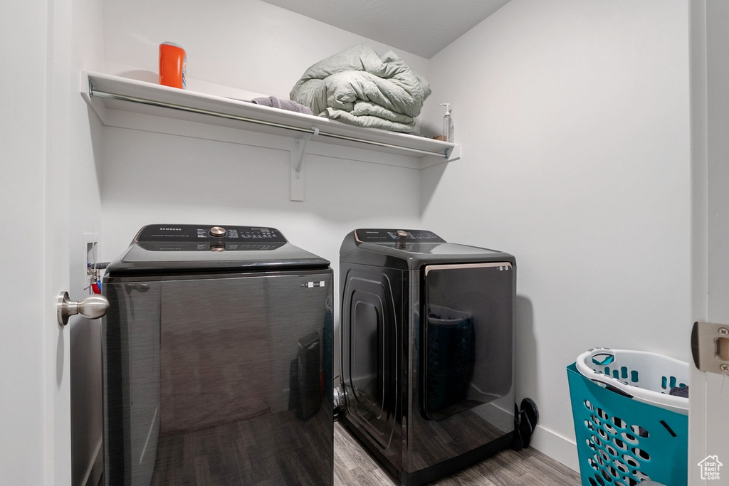 Washroom with laundry area, separate washer and dryer, and wood finished floors