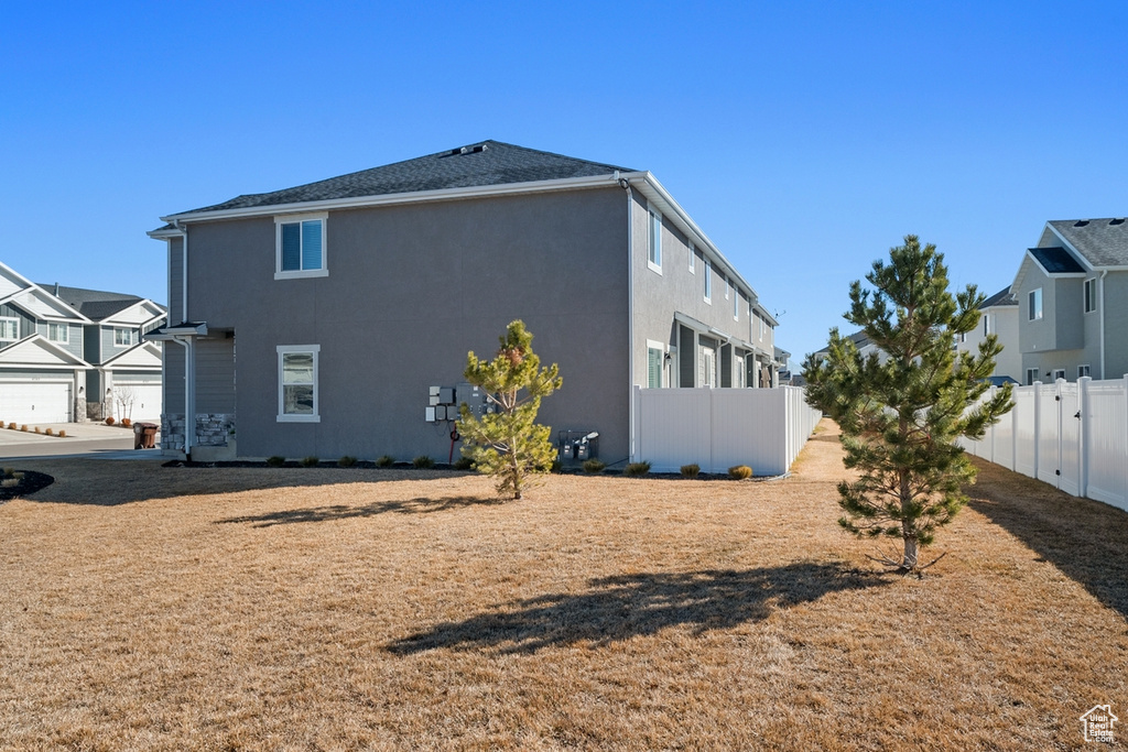 View of side of property featuring fence and stucco siding