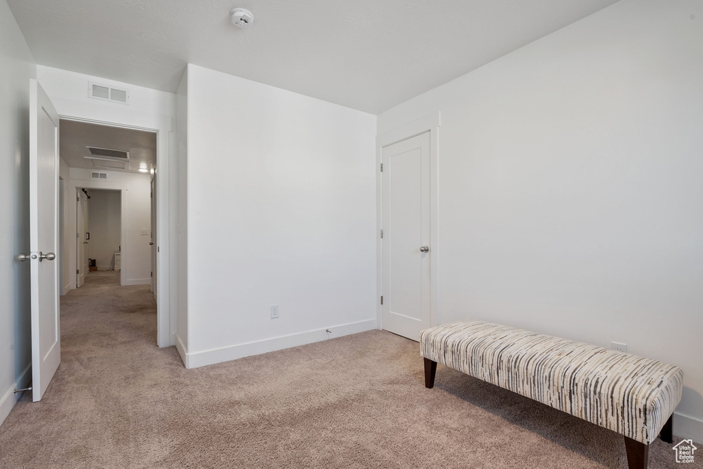 Sitting room featuring visible vents, light carpet, and baseboards