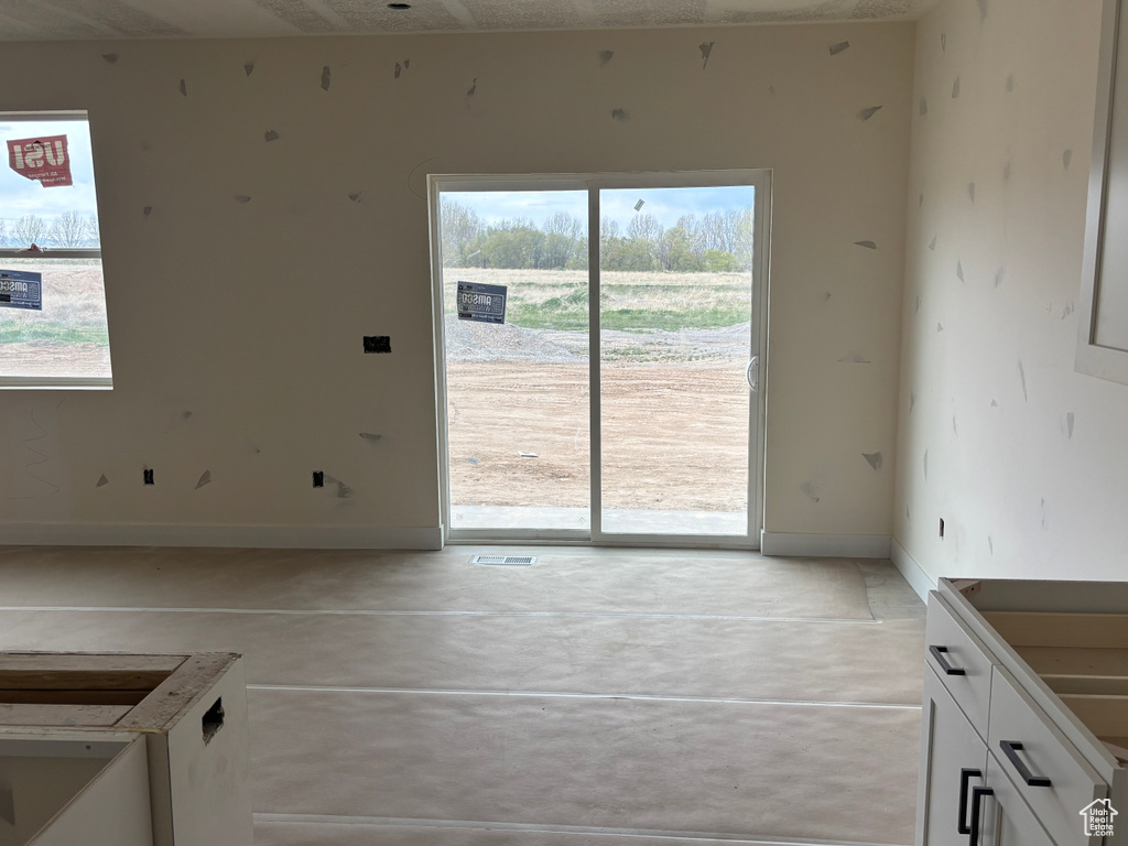 Unfurnished dining area with concrete flooring and baseboards