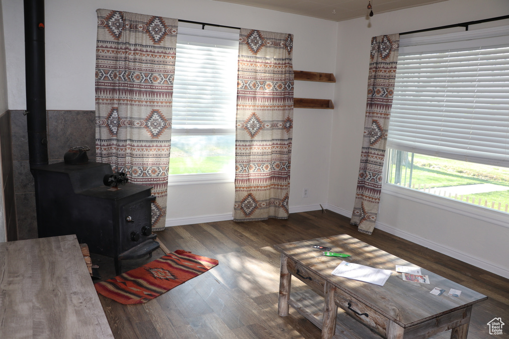Sitting room featuring a wood stove, wood finished floors, and baseboards