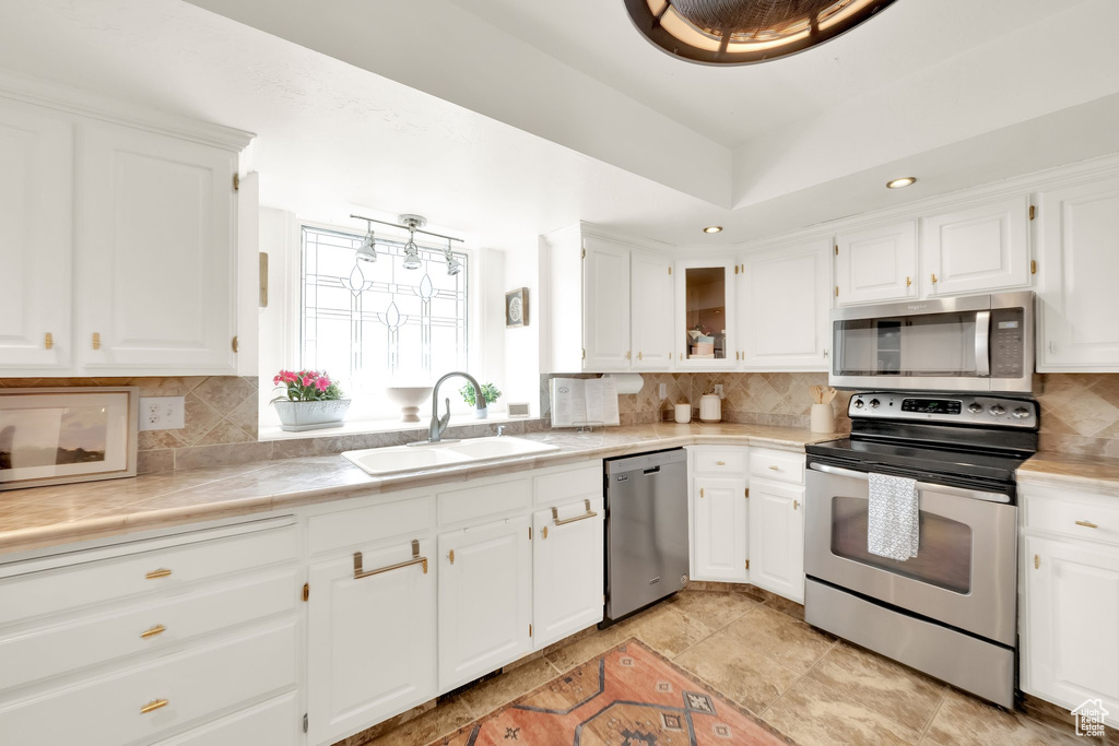 Kitchen with white cabinets, stainless steel appliances, and a sink