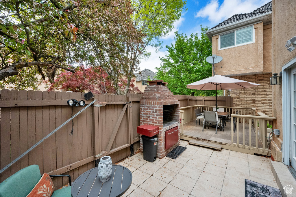 View of patio / terrace with a fenced backyard, outdoor dining space, and a fireplace