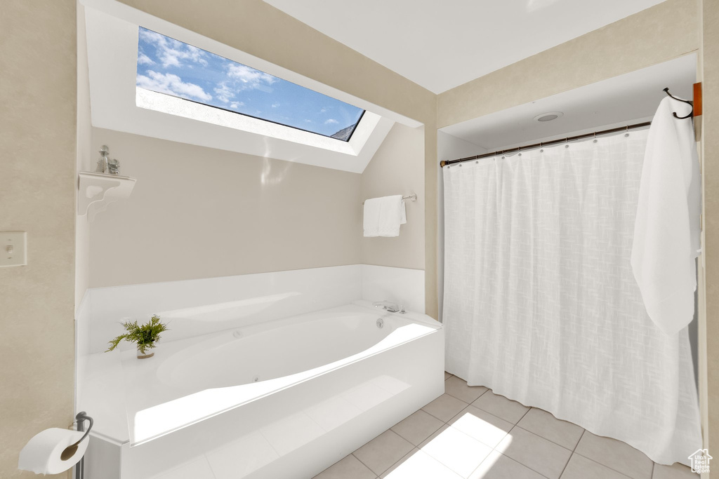 Full bathroom with a bath, tile patterned floors, and a skylight