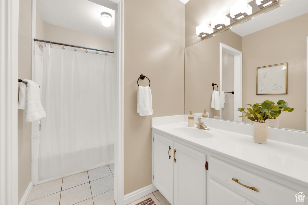 Full bathroom featuring baseboards, tile patterned floors, and vanity