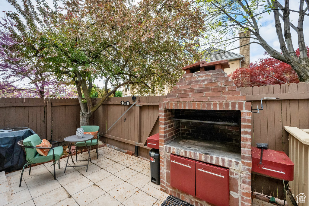 View of patio with a fenced backyard and a grill