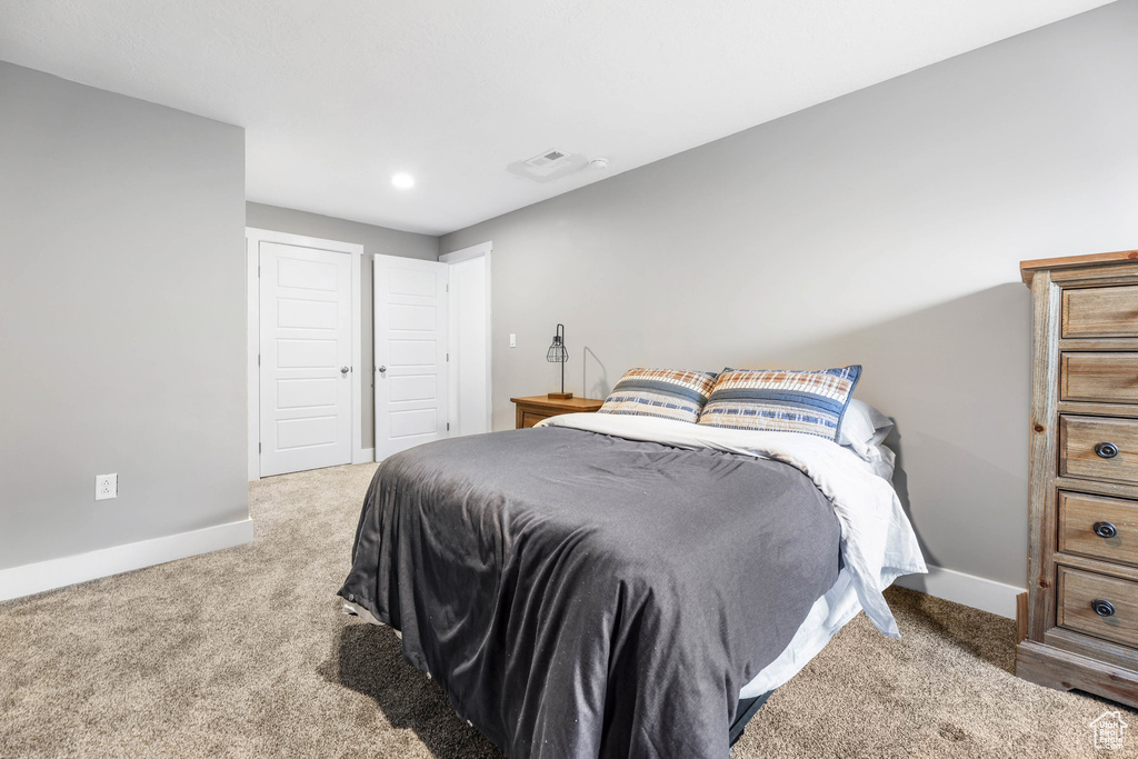 Carpeted bedroom featuring visible vents and baseboards