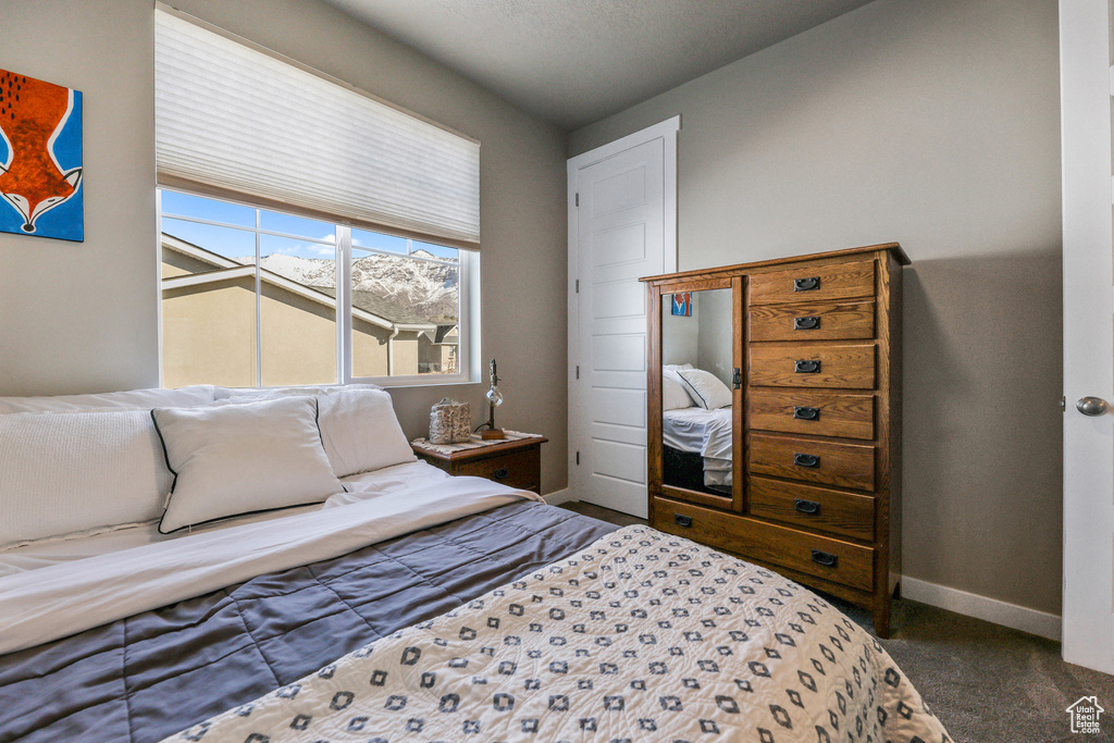 Bedroom featuring carpet and baseboards