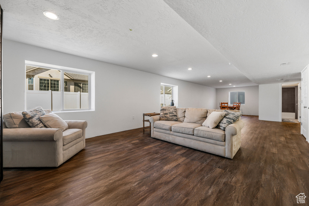 Living area featuring a textured ceiling, wood finished floors, and recessed lighting