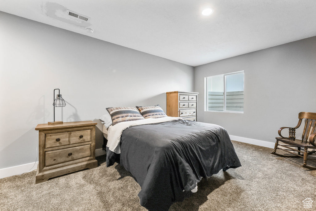 Carpeted bedroom featuring visible vents and baseboards