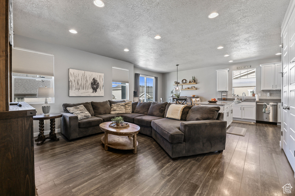 Living room with recessed lighting, dark wood-style flooring, and a textured ceiling