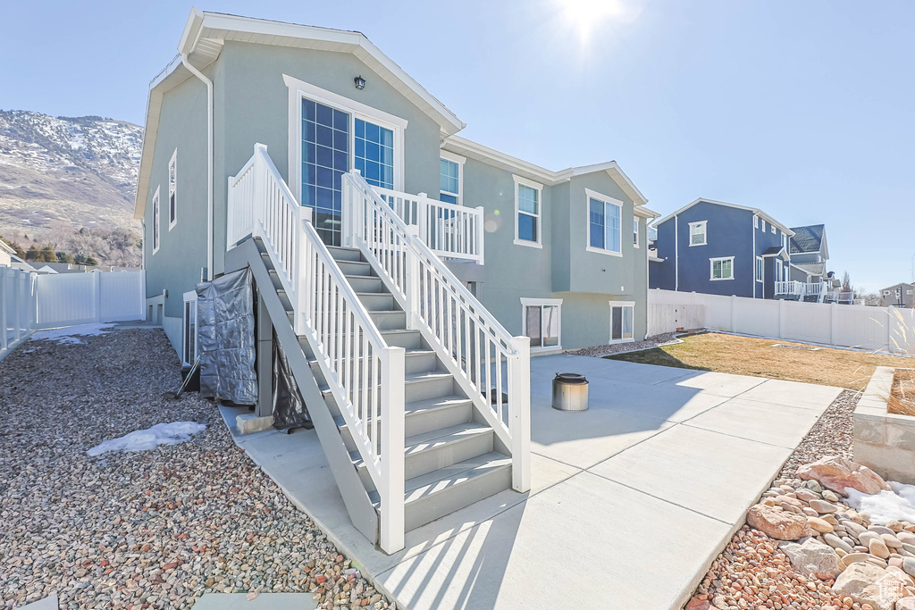 Rear view of property with a patio area, a fenced backyard, stairway, and stucco siding
