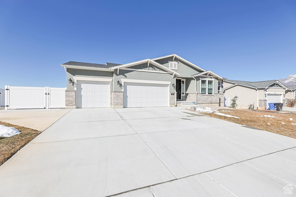 View of front of home featuring stucco siding, concrete driveway, an attached garage, a gate, and fence