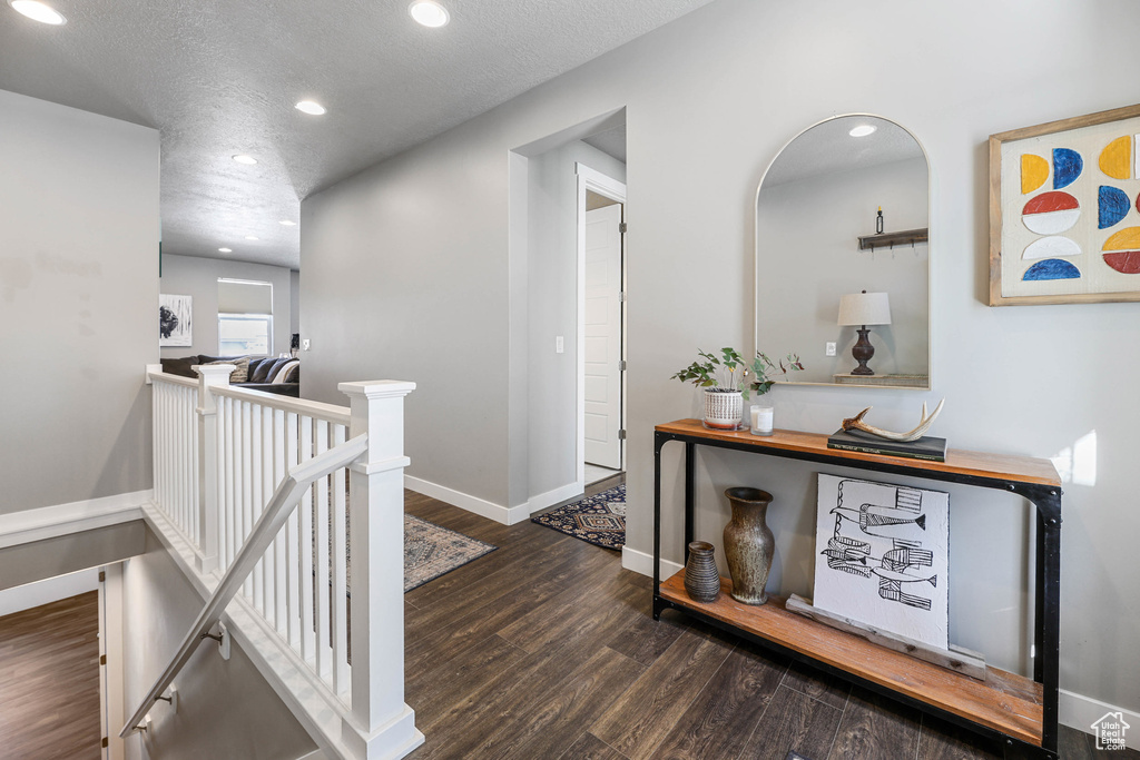 Corridor with recessed lighting, baseboards, an upstairs landing, and wood finished floors