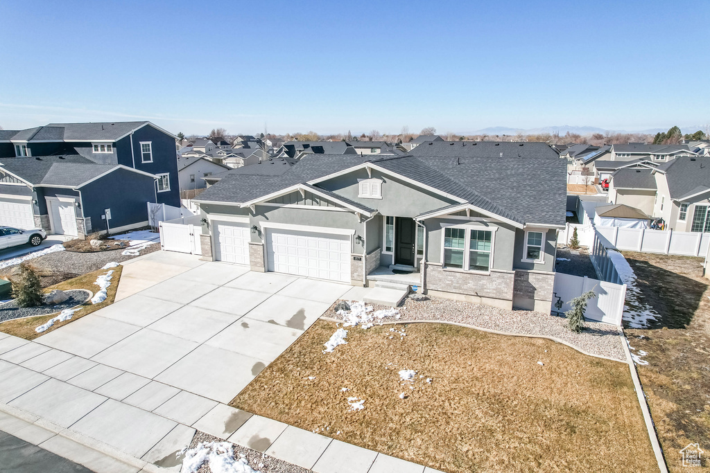 View of front of house featuring an attached garage, fence, and a residential view