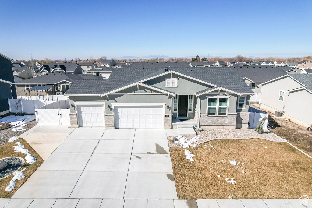 View of front facade with a garage, concrete driveway, a residential view, a gate, and fence