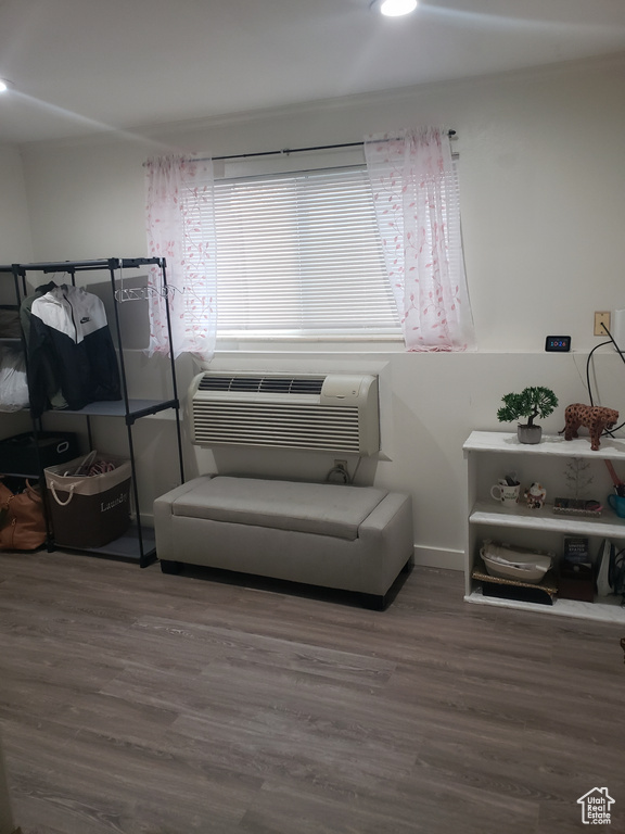 Sitting room featuring a wall unit AC and wood finished floors