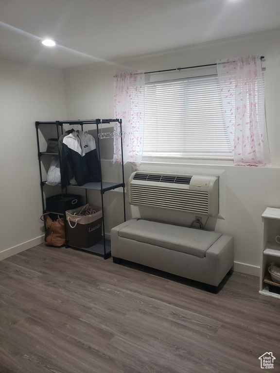 Interior space with baseboards, wood finished floors, and a wall mounted AC