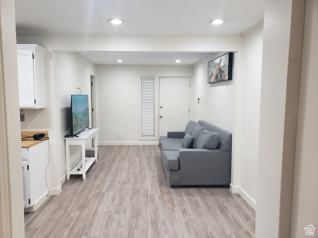 Living room with recessed lighting, baseboards, and light wood finished floors