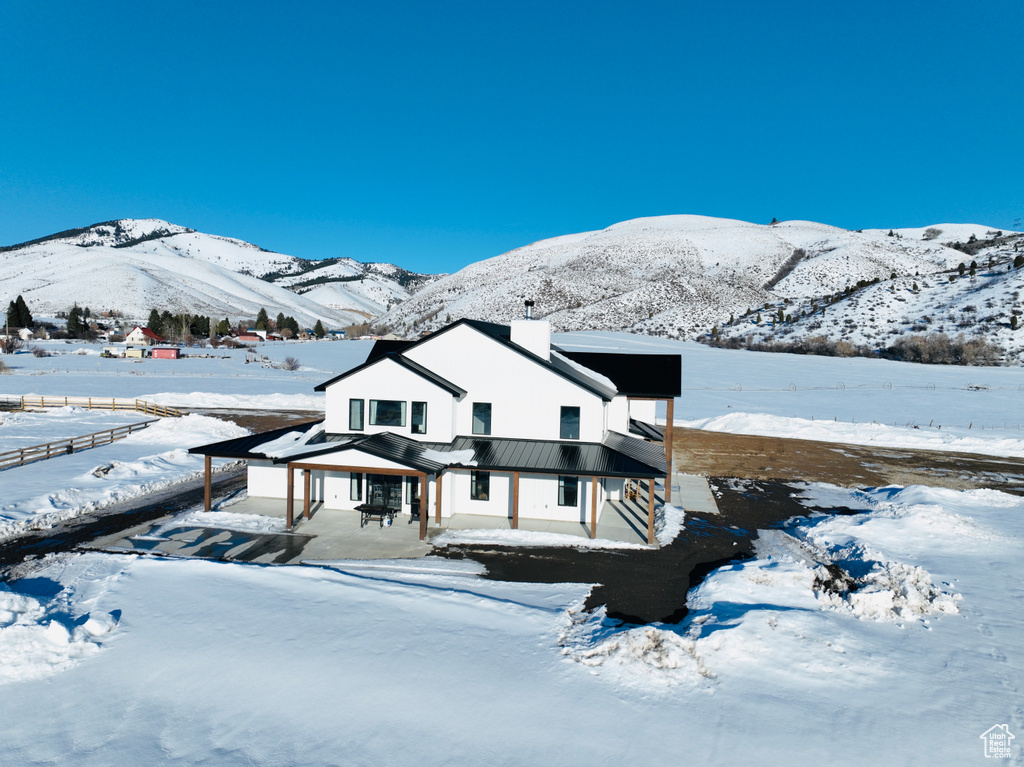Exterior space featuring a standing seam roof, a mountain view, a chimney, and metal roof