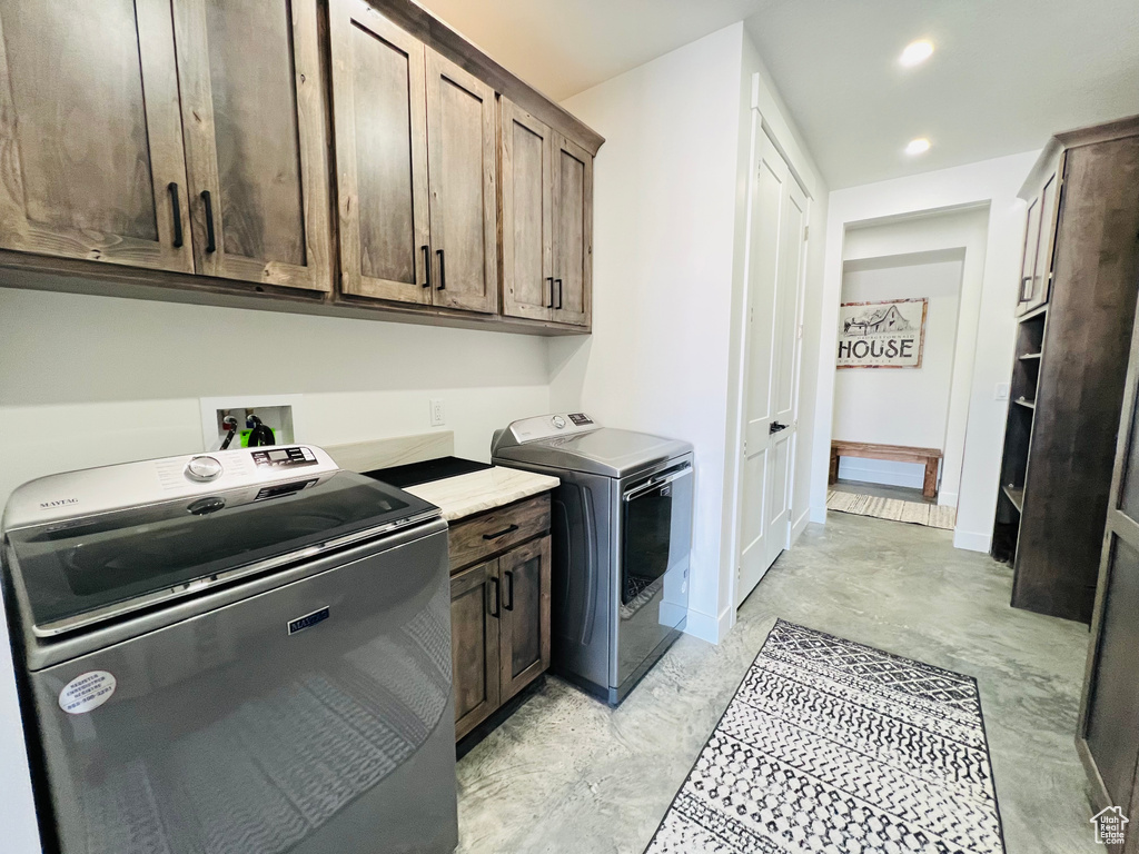 Clothes washing area featuring baseboards, recessed lighting, cabinet space, and washer and dryer