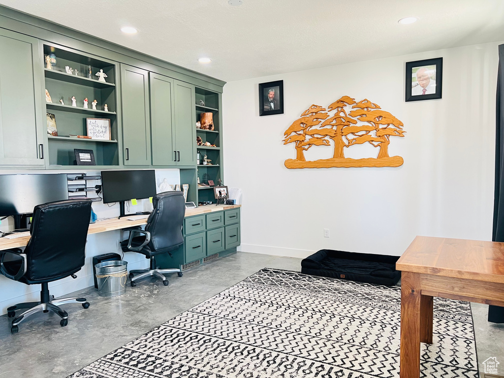 Home office featuring concrete flooring, recessed lighting, built in study area, and baseboards