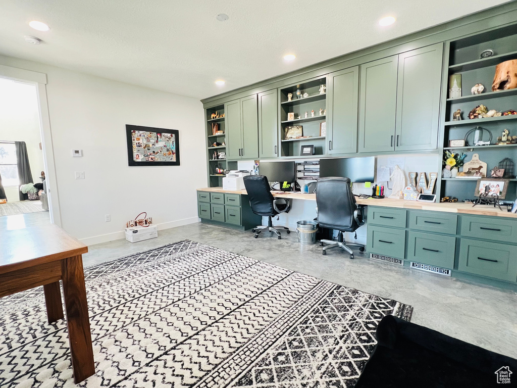 Office area featuring concrete floors, recessed lighting, built in study area, and baseboards