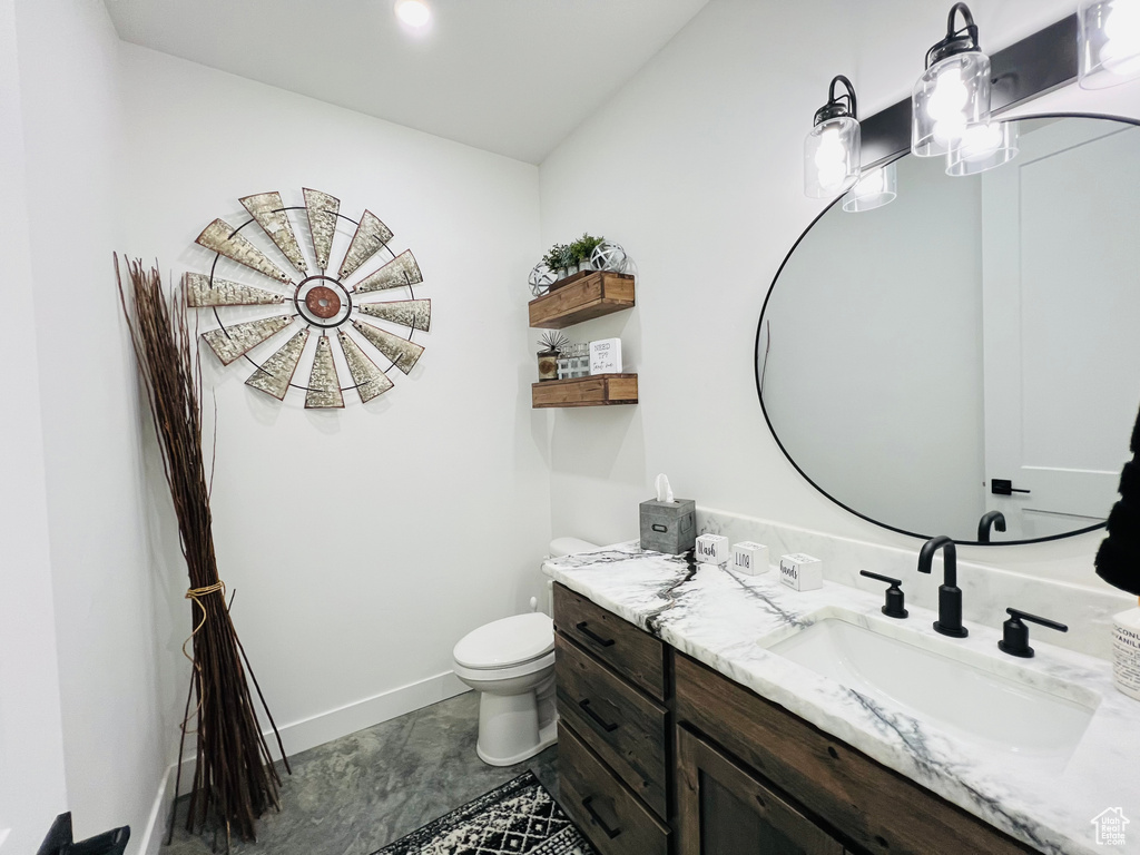 Bathroom with toilet, baseboards, and vanity