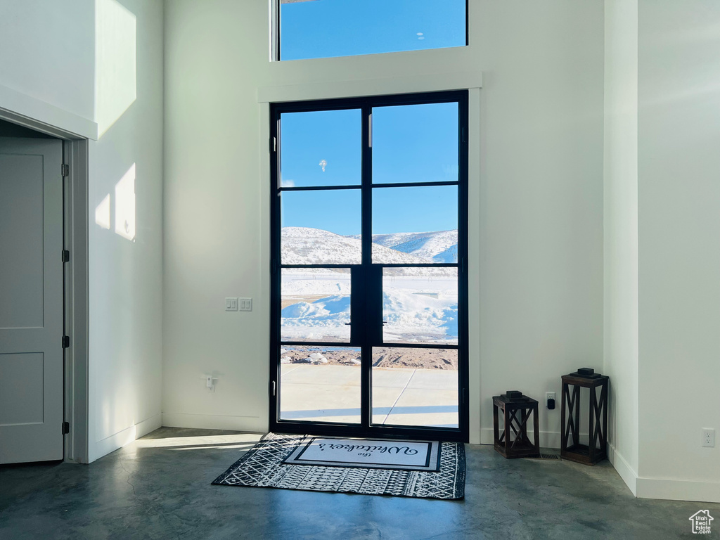 Doorway featuring concrete floors, a mountain view, and baseboards