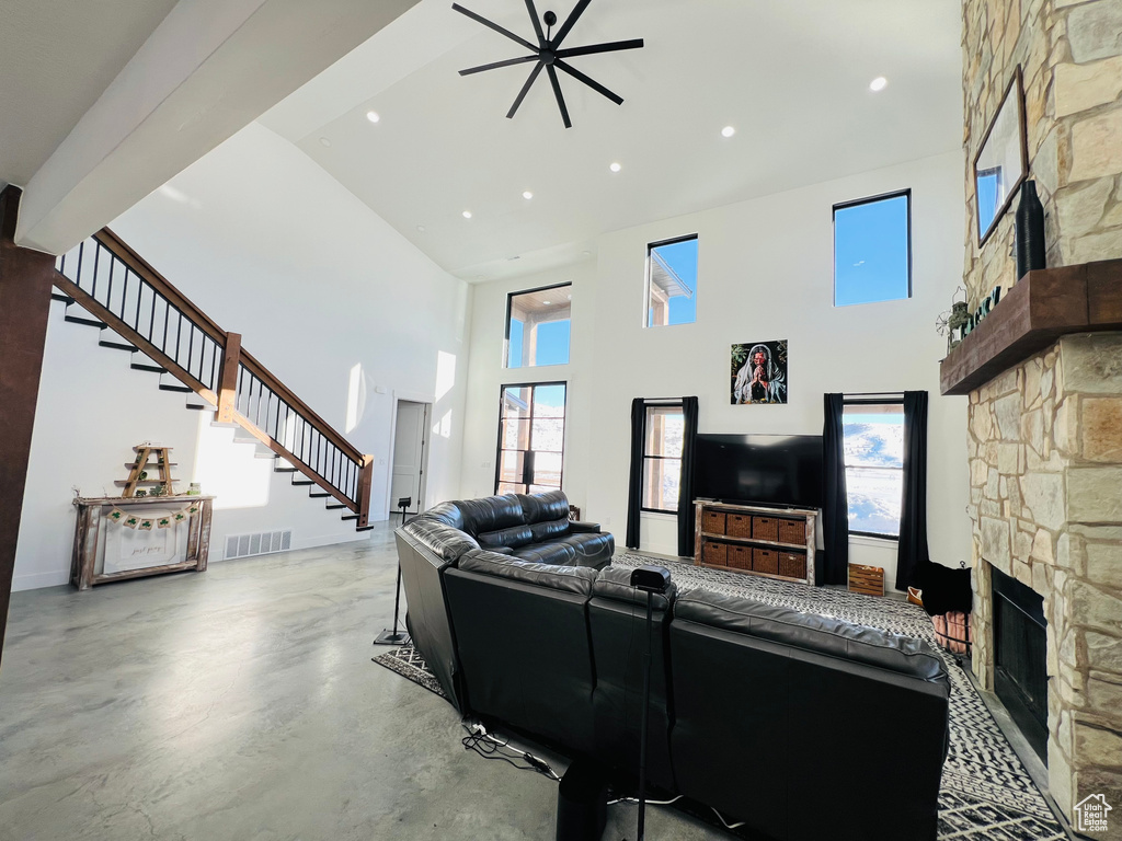 Living area with stairs, a fireplace, visible vents, and a healthy amount of sunlight