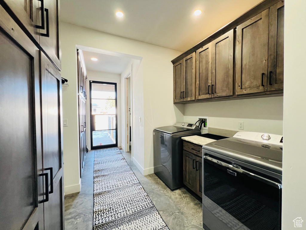 Clothes washing area featuring baseboards, washer and clothes dryer, cabinet space, and recessed lighting