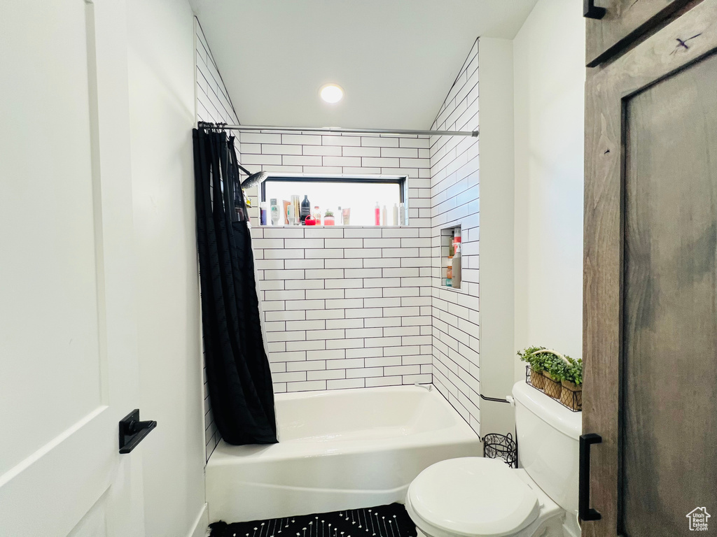 Bathroom with shower / bath combination with curtain and toilet