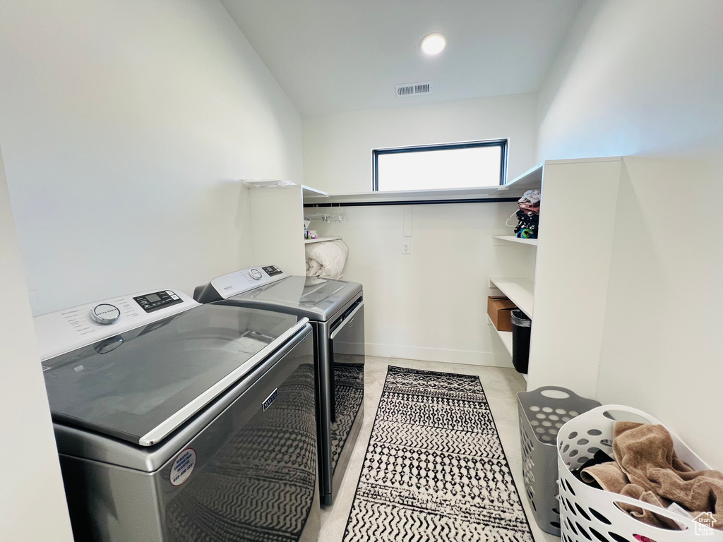 Washroom with laundry area, separate washer and dryer, visible vents, and recessed lighting