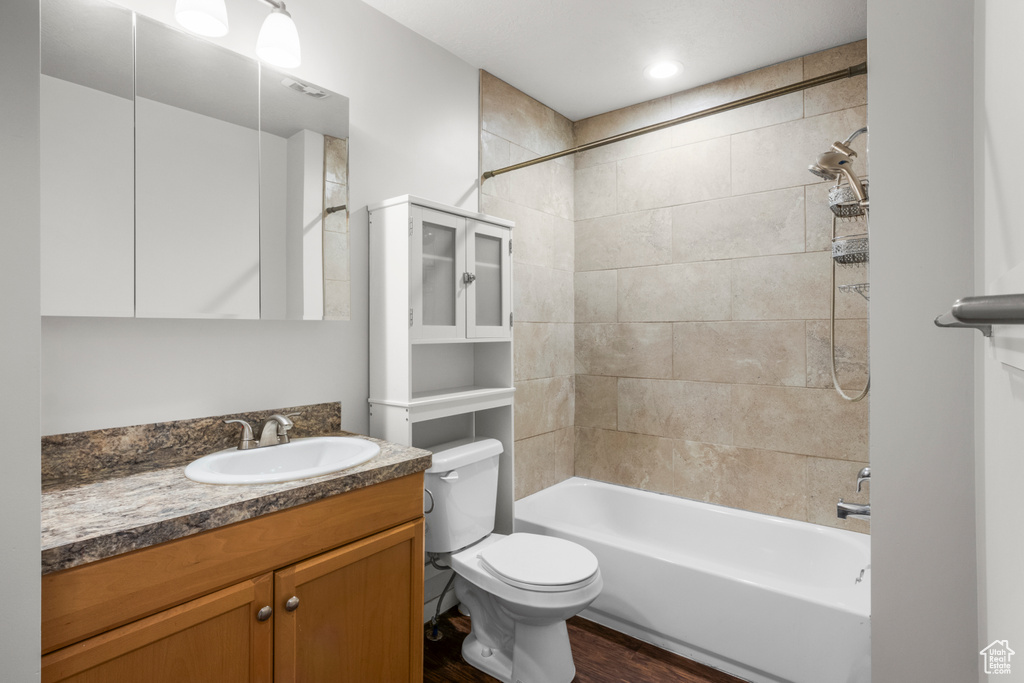 Full bath with toilet, vanity, wood finished floors, and bathtub / shower combination