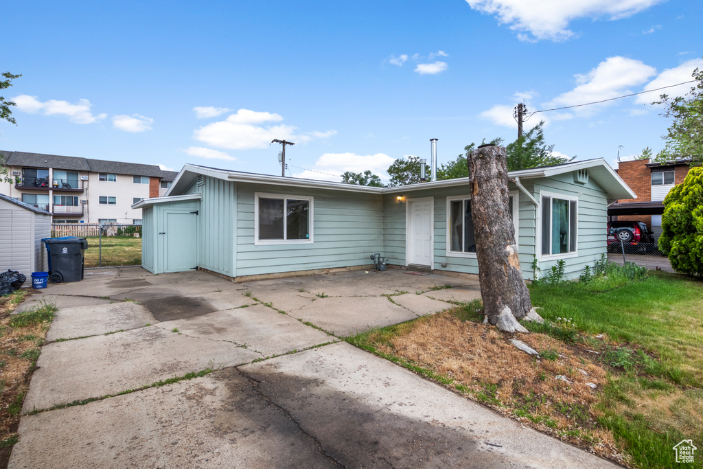 View of front facade featuring driveway and fence