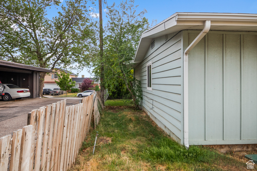 View of side of home with board and batten siding and fence