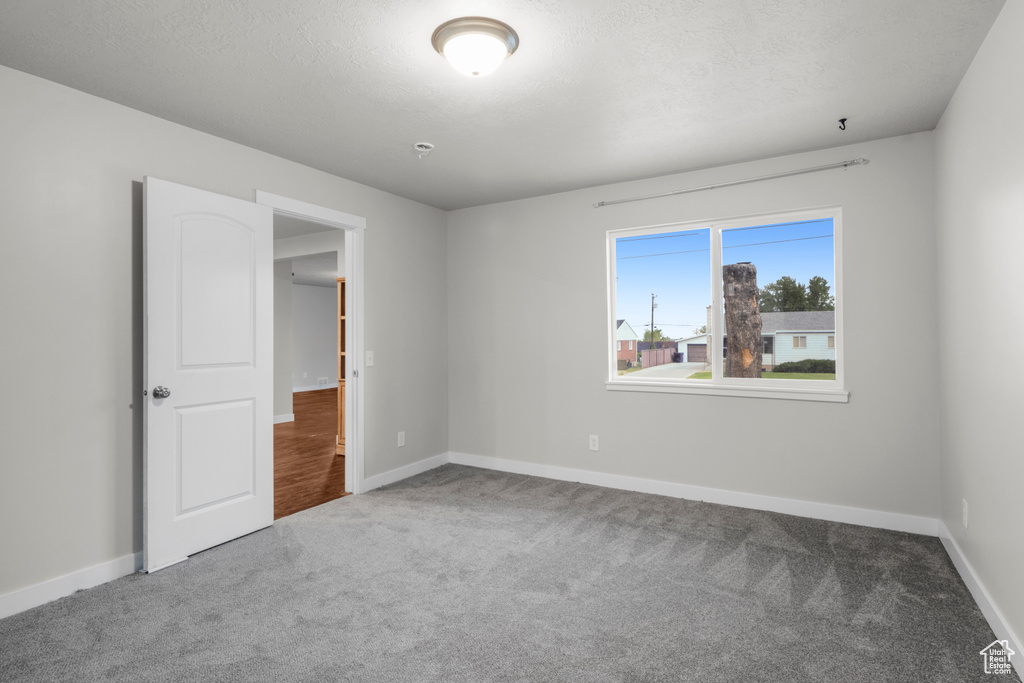 Carpeted empty room featuring baseboards