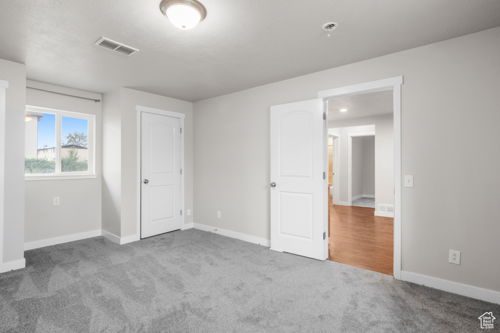 Unfurnished bedroom with carpet floors and baseboards
