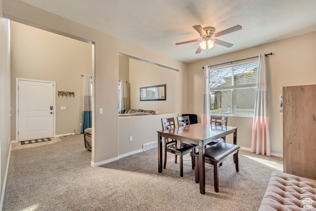 Dining space featuring visible vents, carpet floors, a ceiling fan, and baseboards