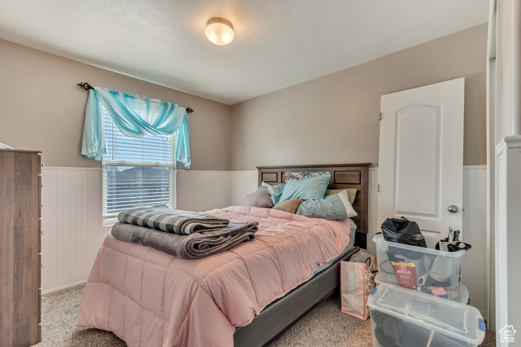 Bedroom with carpet floors and wainscoting